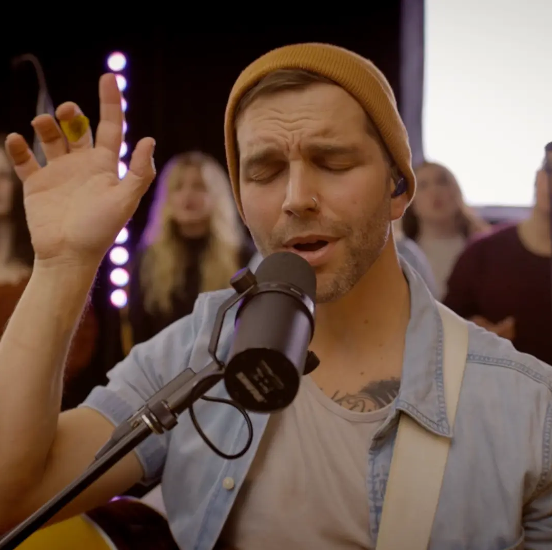 Justin Huey singing into a microphone during a live session